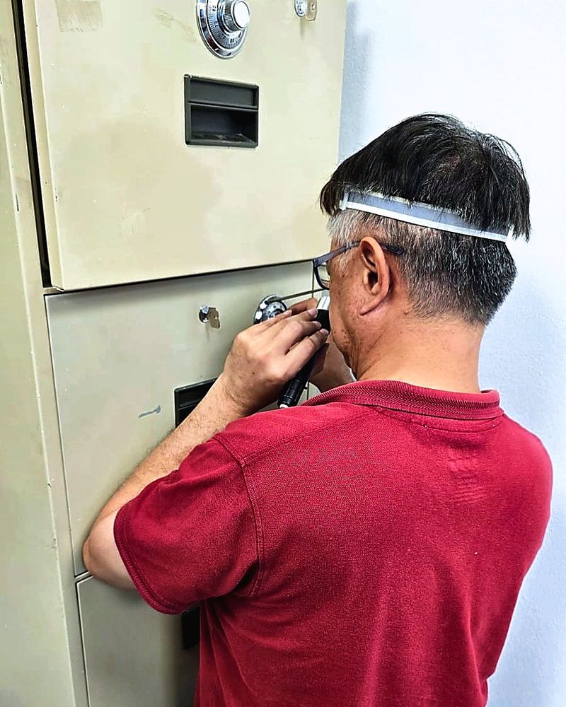 Uncle Thomas working the dial of a combination lock on a filing safe